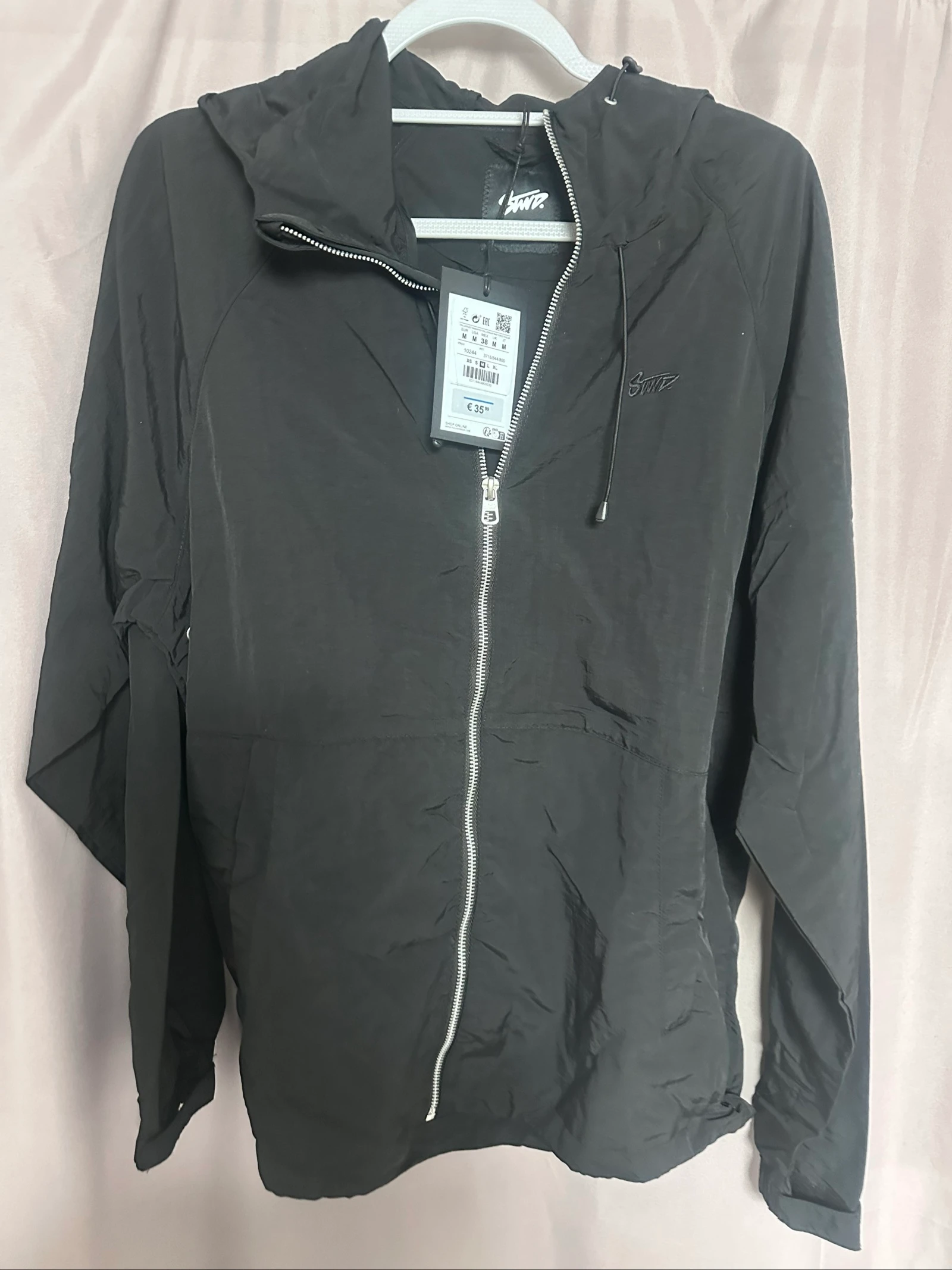 Veste à capuche noire écriture sur le dos coupe-vent